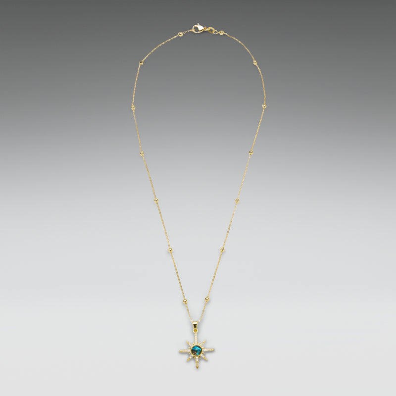 Gold necklace with a star-shaped pendant on a gradient gray background