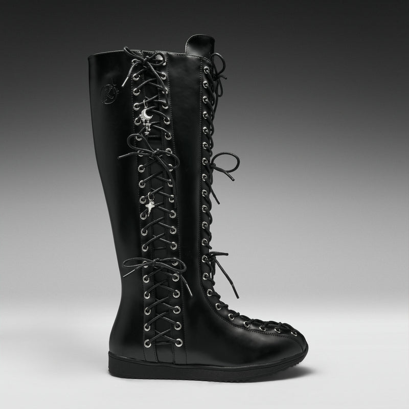 A single black leather knee-high lace-up boot with silver metal eyelets and decorative skull-and-crossbones laces, shown in profile against a dark gray studio background.