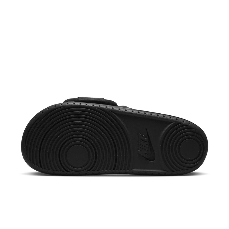 Black slide sandals outsole with circular traction pattern and NIKE logo