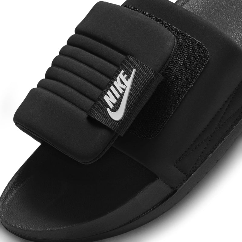 Black slide sandal with thick padded strap and NIKE logo detail
