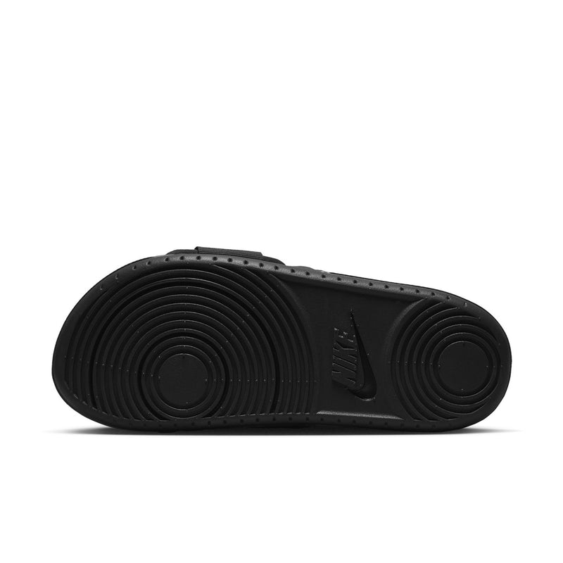 Women’s black slide sandal outsole with circular traction pattern and Nike mark