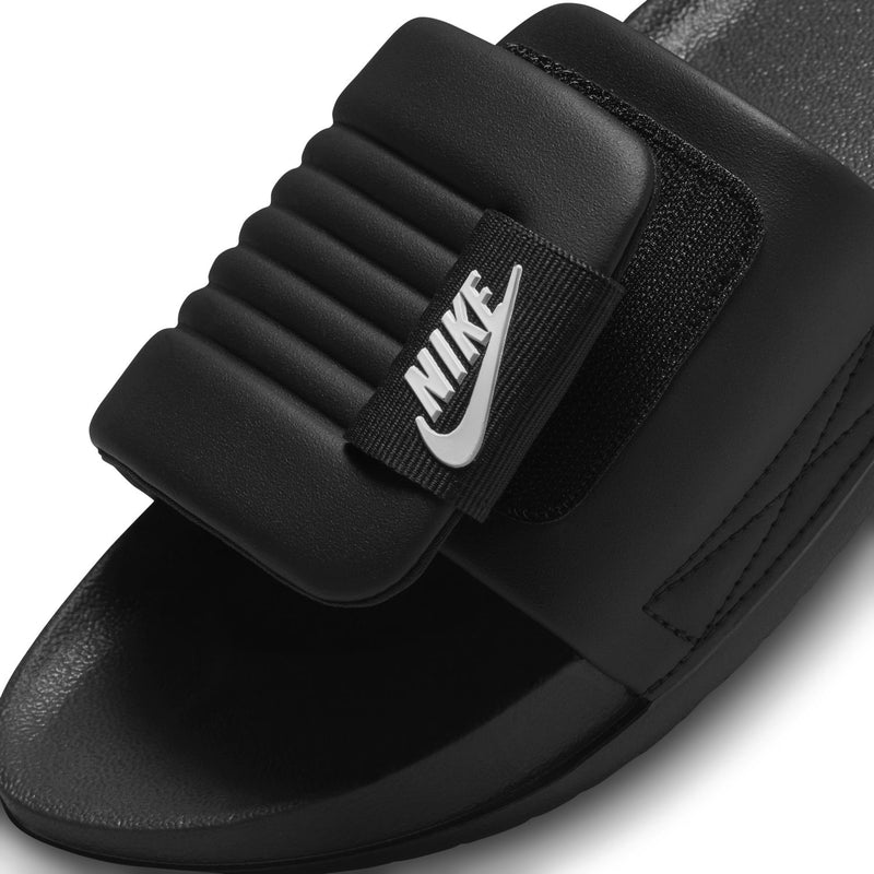 Women’s black slide sandal close-up with white Nike logo on the strap