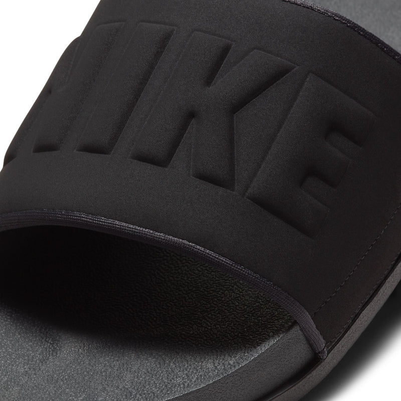 Men's slide sandal close-up of black molded logo strap and cushioned edge