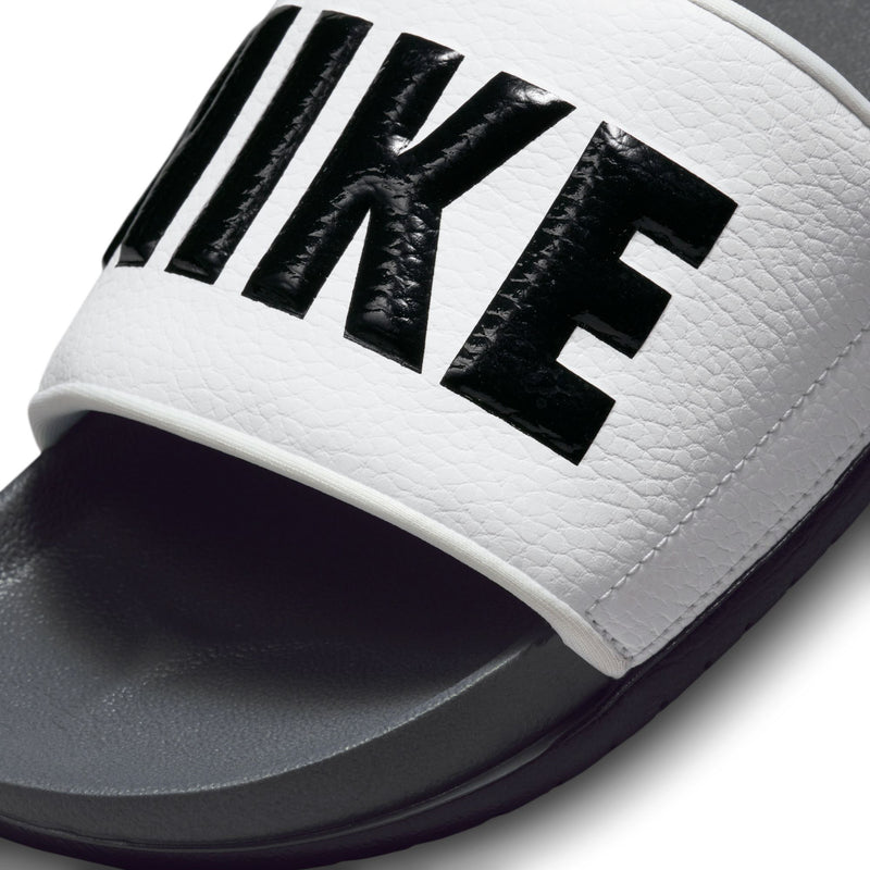 Men's slide sandals close-up: white textured strap with black Nike lettering