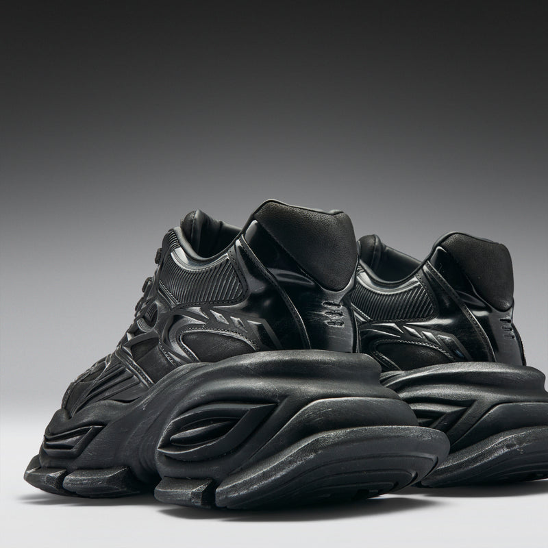 Black sneakers on a gradient gray background