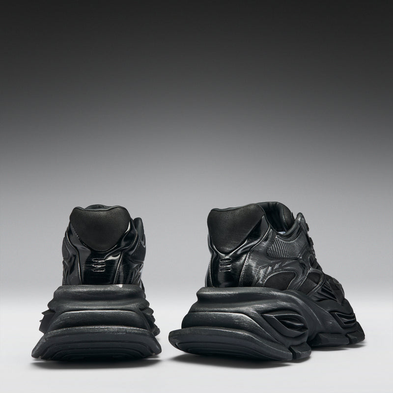 Pair of black sneakers on a gradient gray background