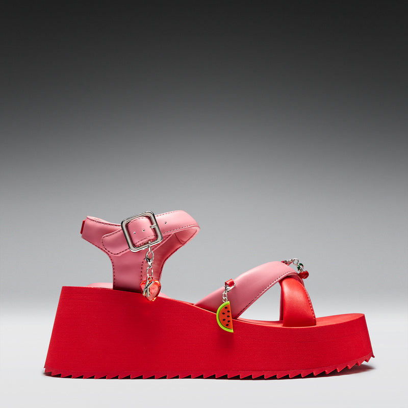 Red sandal with a watermelon charm on a gray background