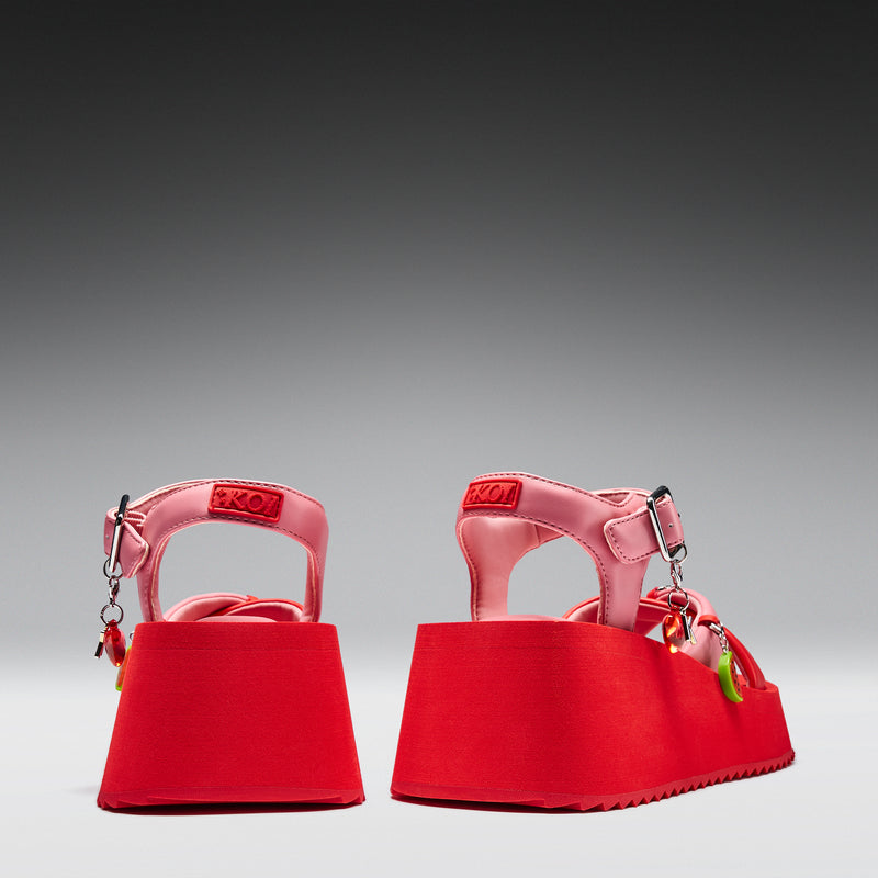 Pair of red sandals with a gray background