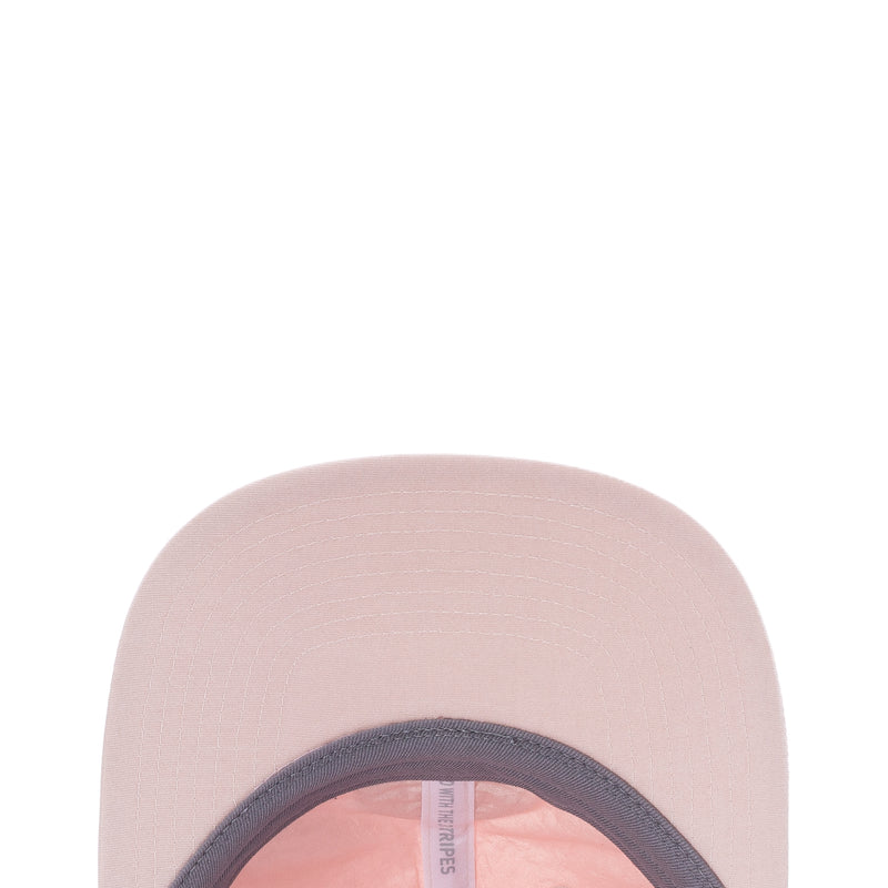 Light pink strapback cap showing inner opening and side tag near brim