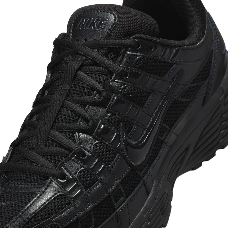 Men's black Nike running shoe close-up, mesh laces and swoosh detail