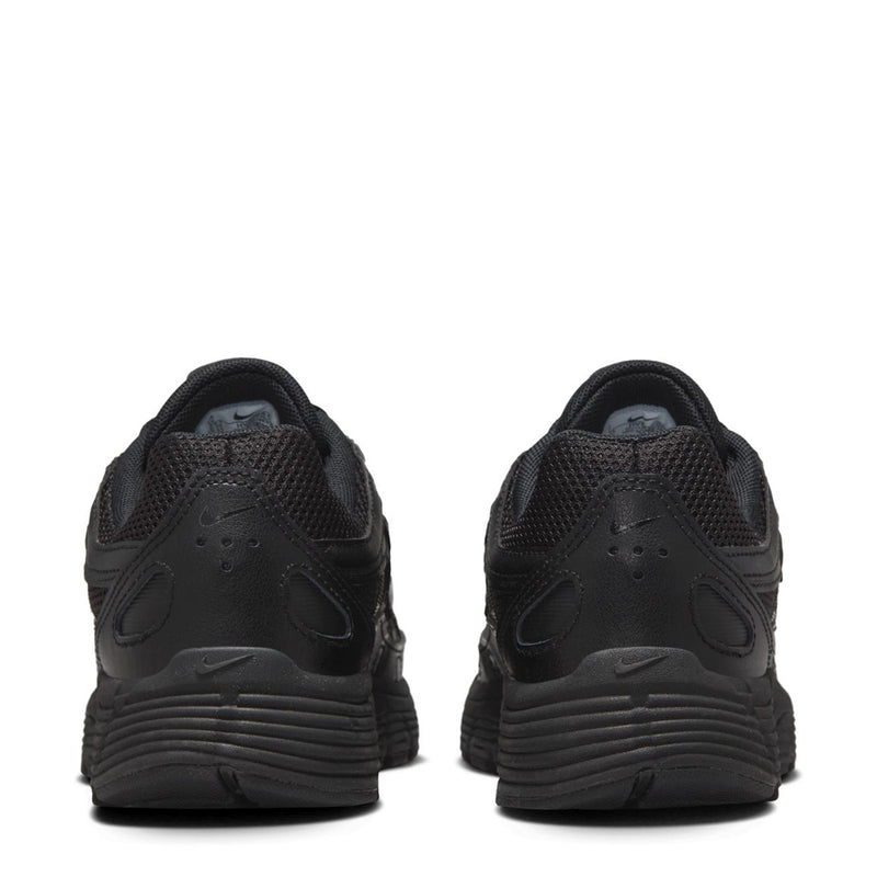 Black sneakers heel view with textured panels and ribbed midsole