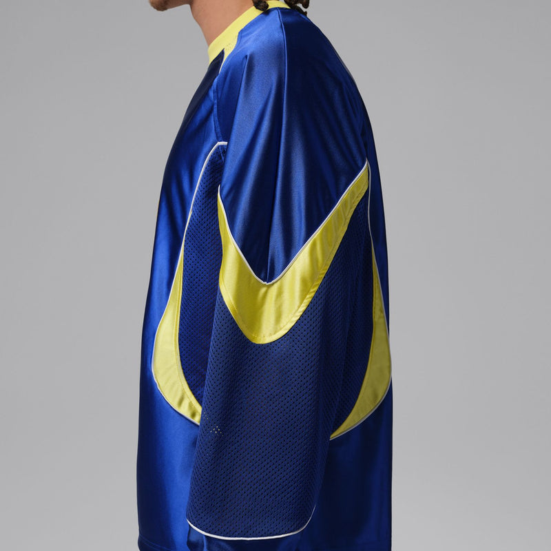 Side view of royal blue goalie jersey with yellow swoosh-style sleeve trim.