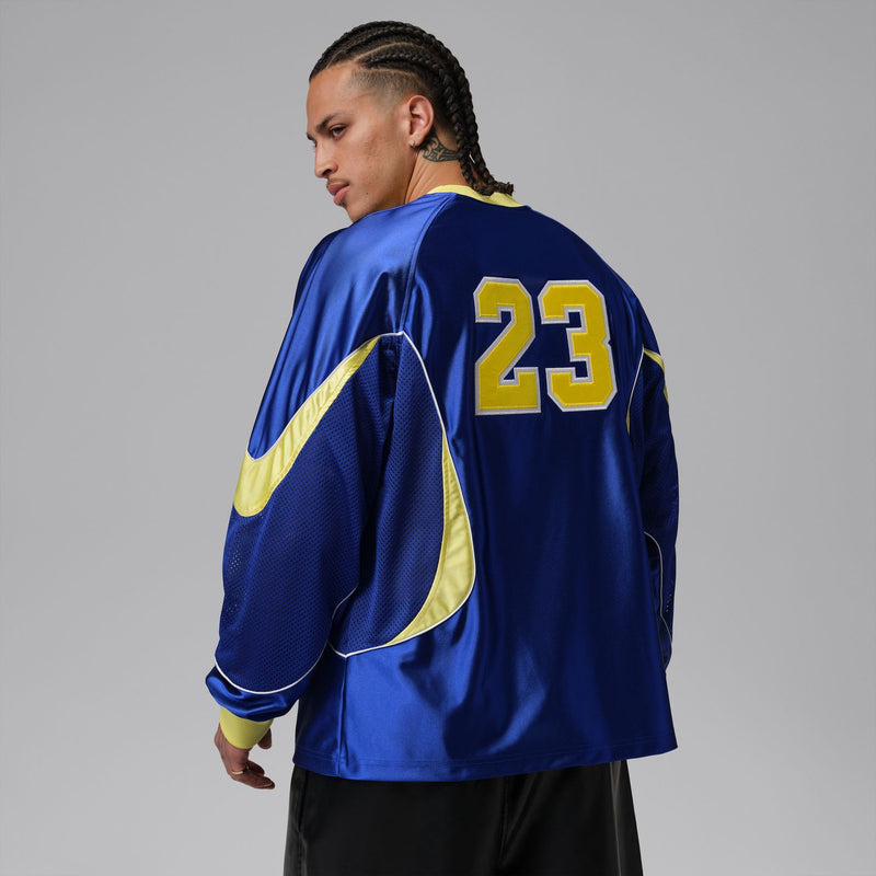 Back view of royal blue goalie jersey with yellow number 23 and curved trim.