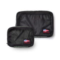 The Packing Cube Bundle includes two black ultra-light nylon cubes with GORUCK logo patches and American flag designs for sleek travel organization, displayed on a white background.
