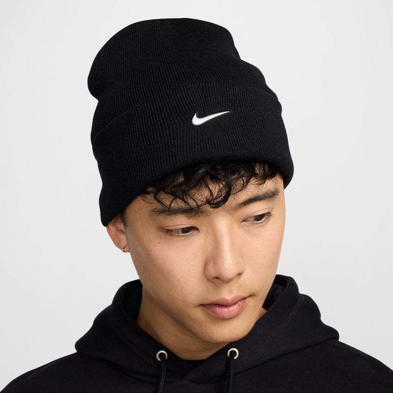 Black tall beanie with fold cuff and white Nike swoosh logo, worn
