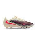 Men's low-cut soccer cleat in cream and burgundy with red swoosh and patterned side