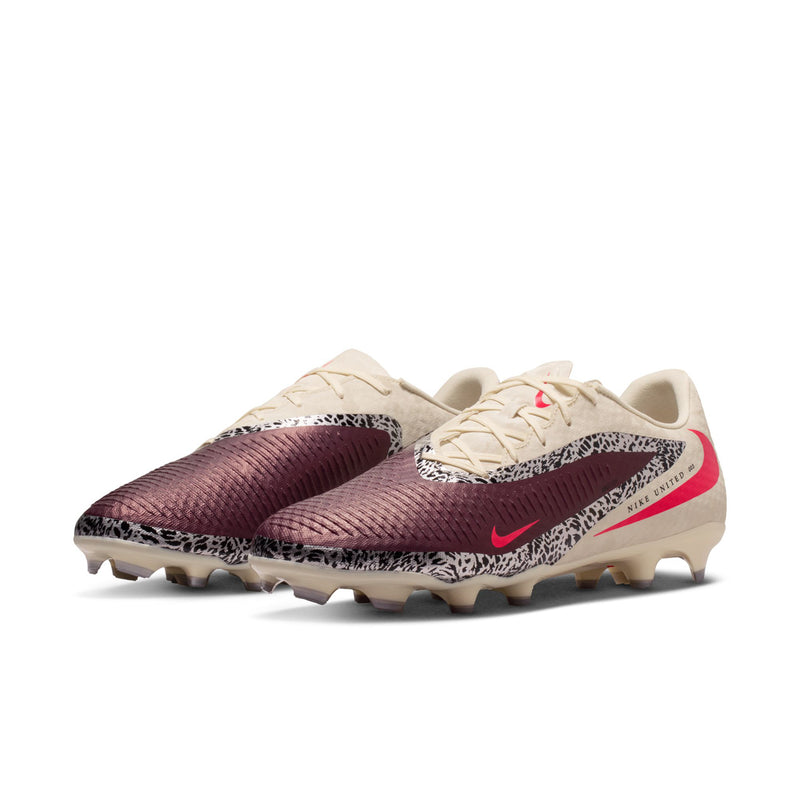 Men's soccer cleat side view: cream upper, burgundy toe, red swoosh, studded sole