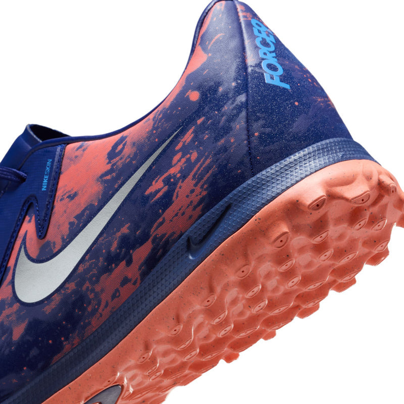 Close-up of men's dark blue turf shoe outsole with orange-tinted tread