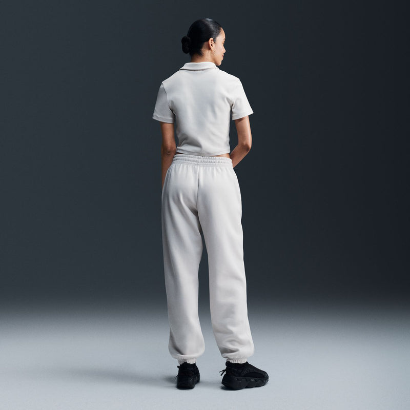 Women’s off-white jogger pants, back view: elastic waistband, drawstring, cuffed tapered legs