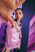 Person wearing a pink outfit with a cityscape background