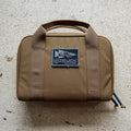 The brown Pistol Rug with handles and a "GORUCK Tactical" patch sits on a light textured surface—ideal as a modular pistol case or magazine pouch.
