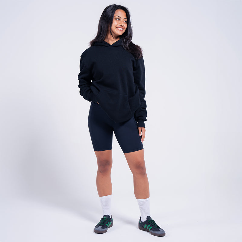 Women's black fleece pullover hoodie, side view with hood and kangaroo pocket
