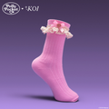 Pink sock with lace and bow detail on a purple background, featuring Polly Pocket branding.