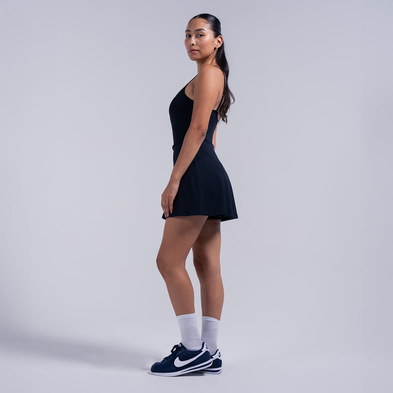 Black A-line skater dress side view with spaghetti straps and flared skirt
