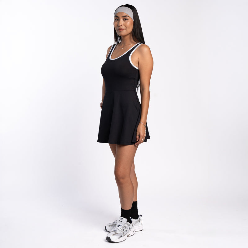 Black sleeveless skater dress with white-trim scoop neck, above-knee length