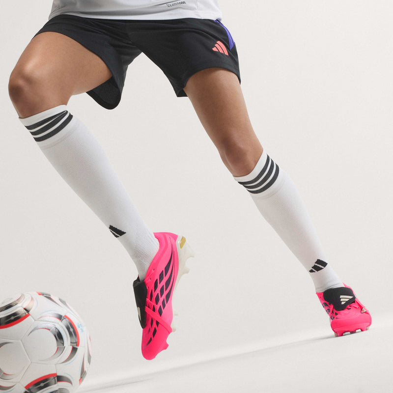 Men's soccer cleats, pink with black detailing and white socks visible