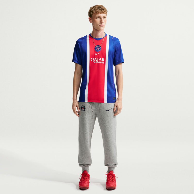 Men's PSG home stadium replica jersey, blue with red/white vertical stripe; worn with gray pants
