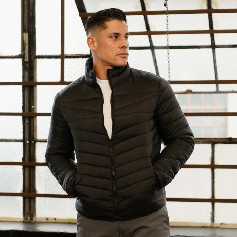 Men's black puffer jacket with stand collar, zip front, and horizontal quilted channels