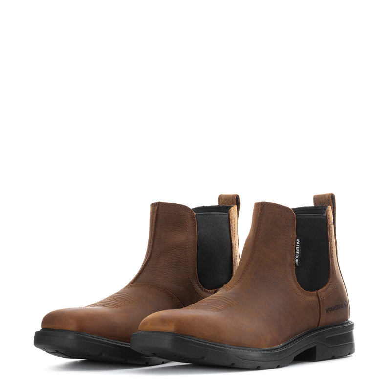 Pair of brown Chelsea ankle boots with elastic side panels and black tread sole