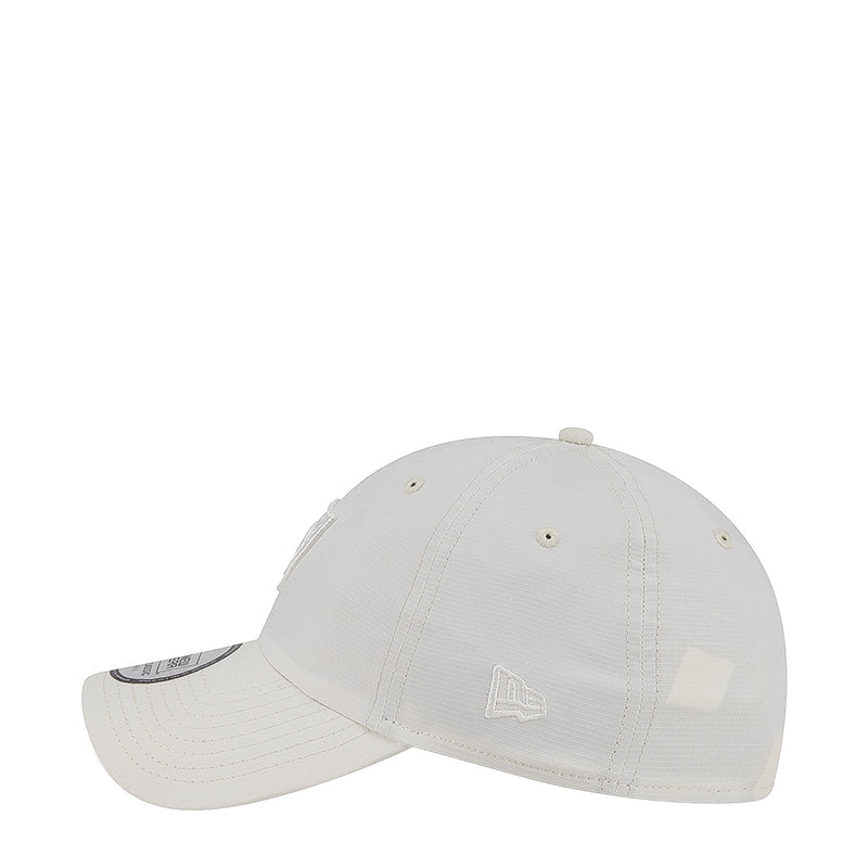 White strapback cap with small side flag emblem and curved brim