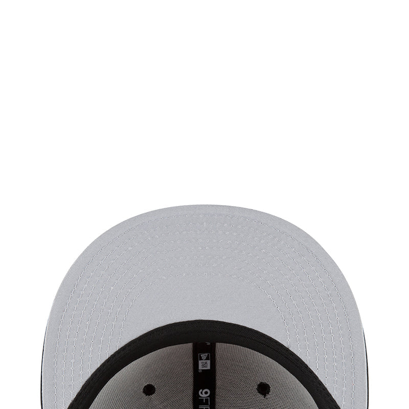 White baseball cap close-up with black inner band and stitched crown panels.