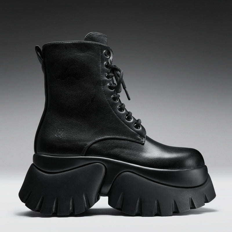 Black leather boot with thick sole on a gradient background