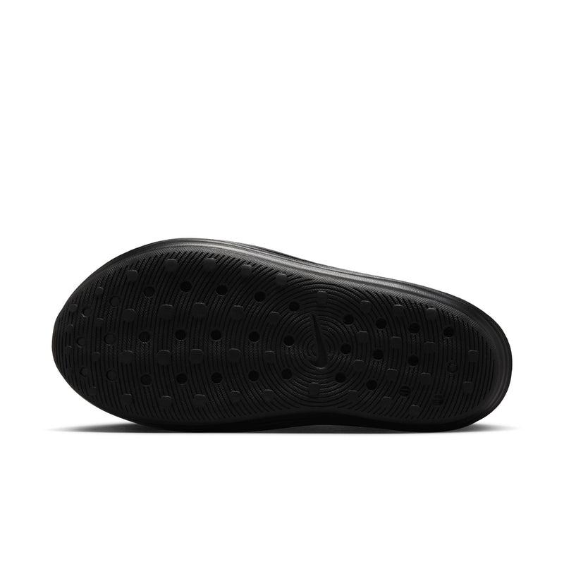 Black outsole of a slip-on clog with patterned tread and traction dots.