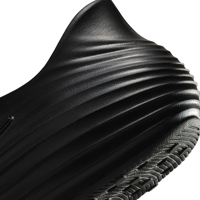 Black molded clog upper with ribbed side texture and woven edge trim detail.