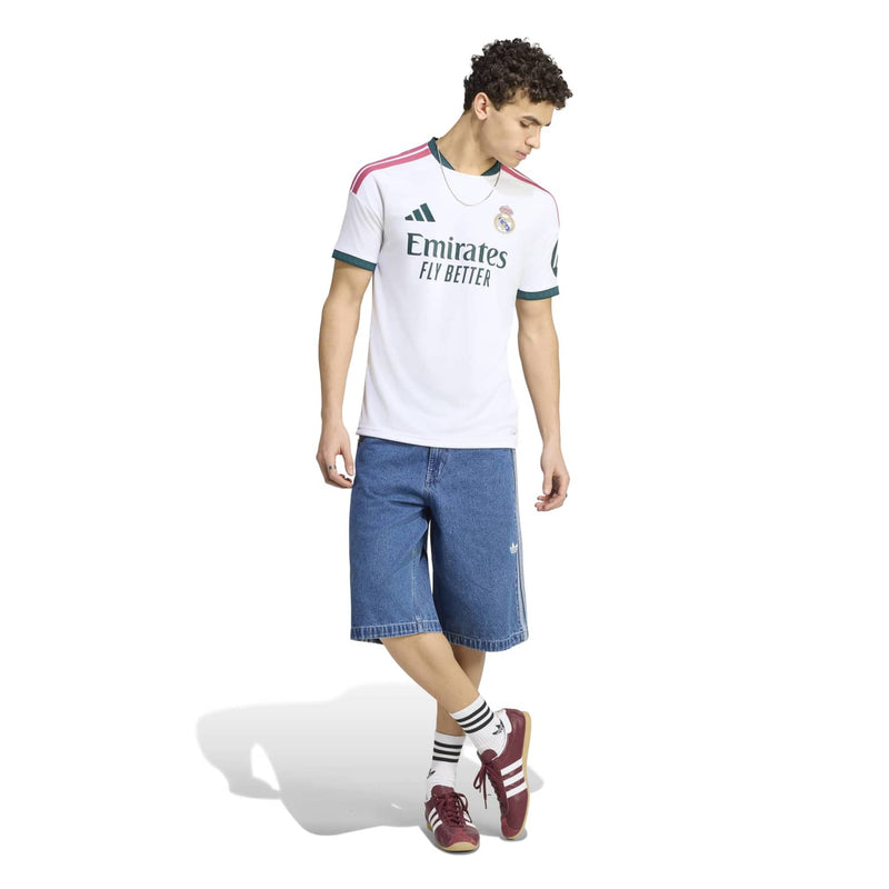 White Real Madrid home replica jersey with green trim and pink shoulder stripes, side view