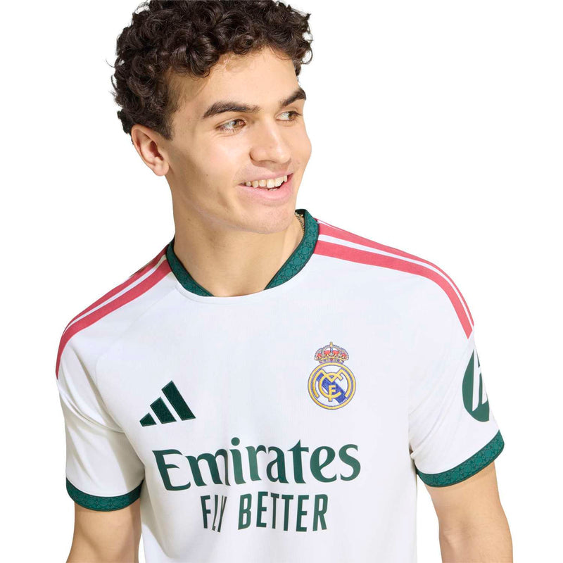 White jersey front with Emirates Fly Better sponsor, Real Madrid crest, and green trim