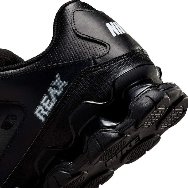 Men's black Nike training shoe close-up, REAX side detail and patterned overlays.