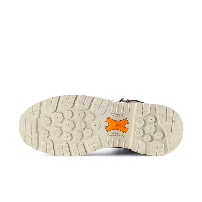 Boot outsole with rugged tread pattern and orange logo patch on off-white rubber.