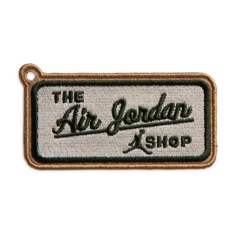 Clothing tag patch reading "The Jordan Shop" with stitched border