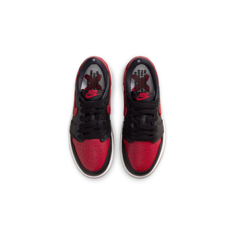 Kids black and red low-top sneakers with laces, showing tongue logos and perforated toe.