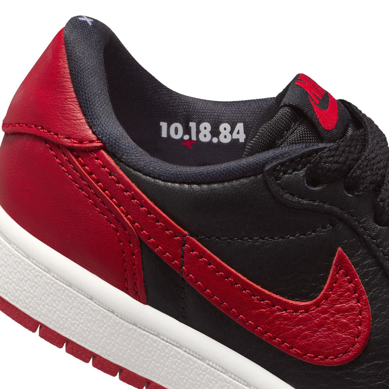 Close-up of kids sneaker collar with “10.18.84” and black/red swoosh detail.