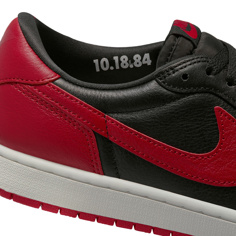 Close-up of black and red sneaker collar with grey lettering on black lining