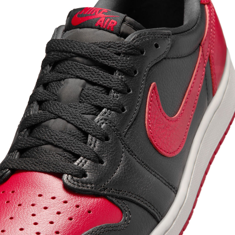 Close-up of black and red low-top sneaker upper with Nike swoosh and laces
