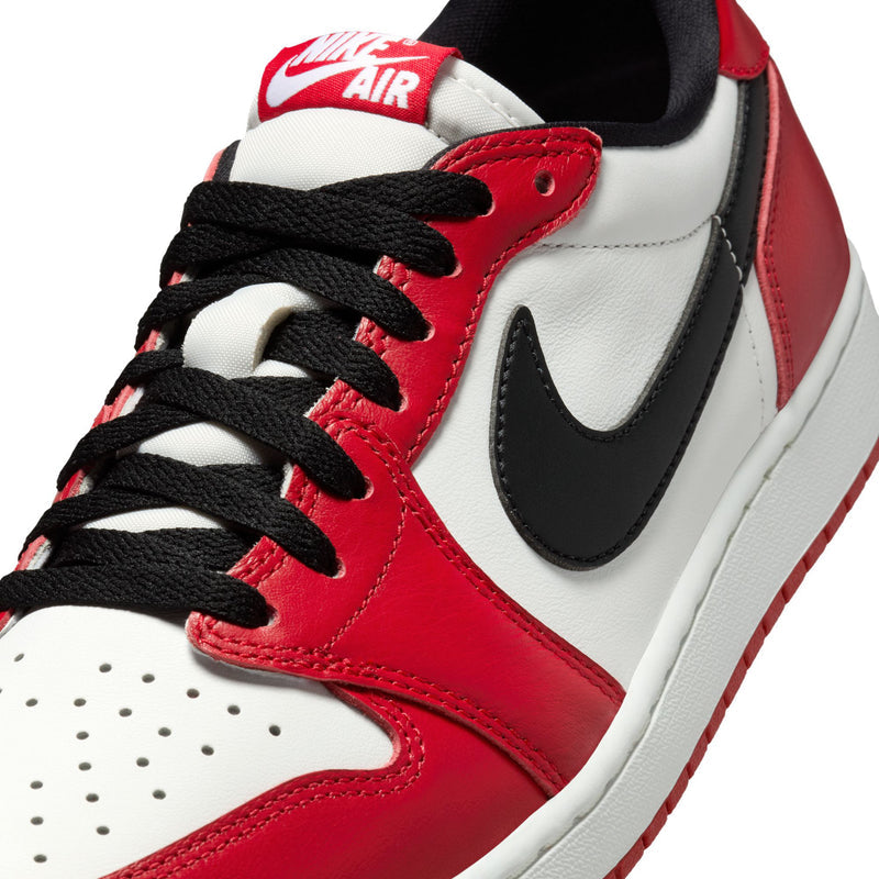 Close-up of men's low-top sneaker upper with red leather, white panel, and black laces
