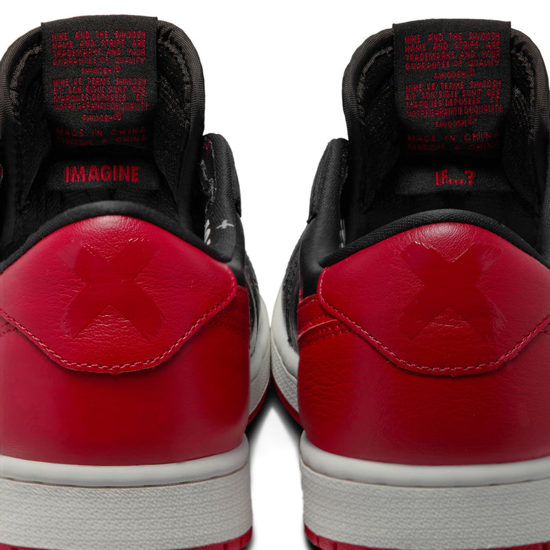 Close-up of black and red sneaker heels showing lace-up opening and inner text