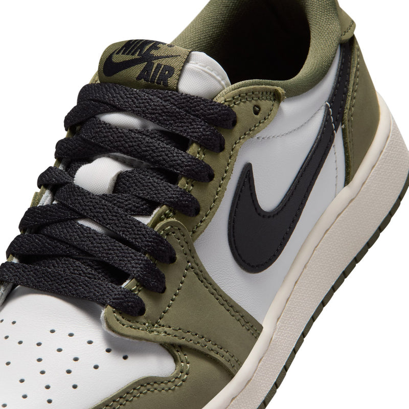 Youth sneaker close-up: olive suede, black laces, white leather toe, swoosh